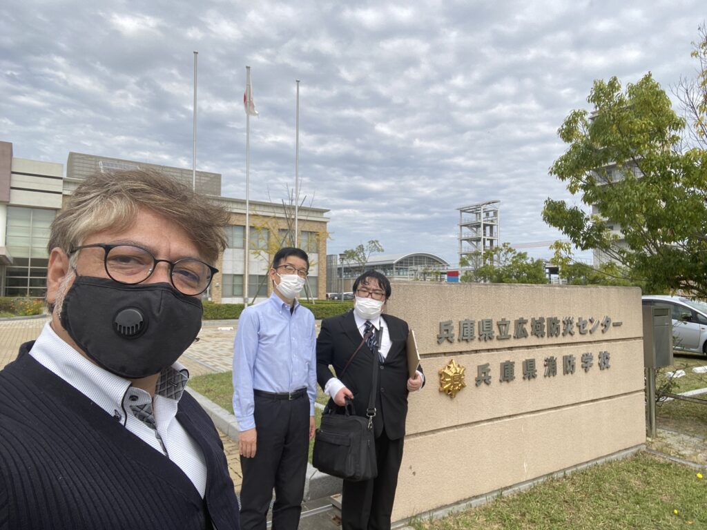The front gate of Hyogo Prefectural Emergency Management and Training Center. From left: Professor Yuri Tijerino, Mr. Kenichi Tanaka from Hyogo Prefectural Emergency Management and Training Center, and Yasushi Miyazaki